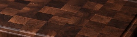 The end-grain surface of a finished walnut board: a chocolate-brown chequer of standing fibre.